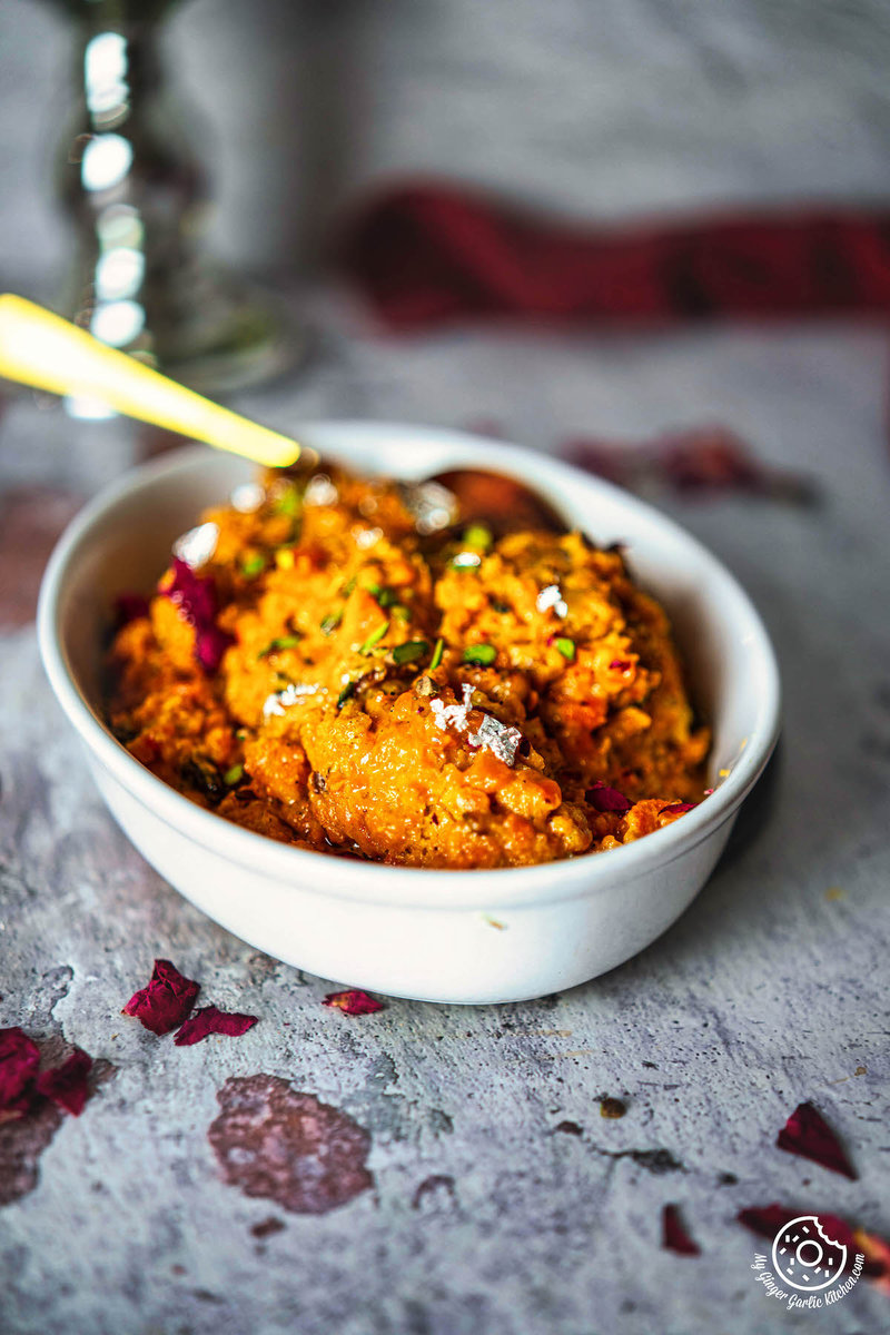 a bowl of pressure cooker carrot halwa with a spoon in it