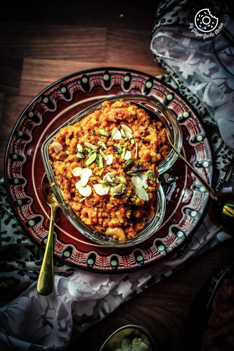 a bowl of instant pot gajar halwa on a plate with a spoon