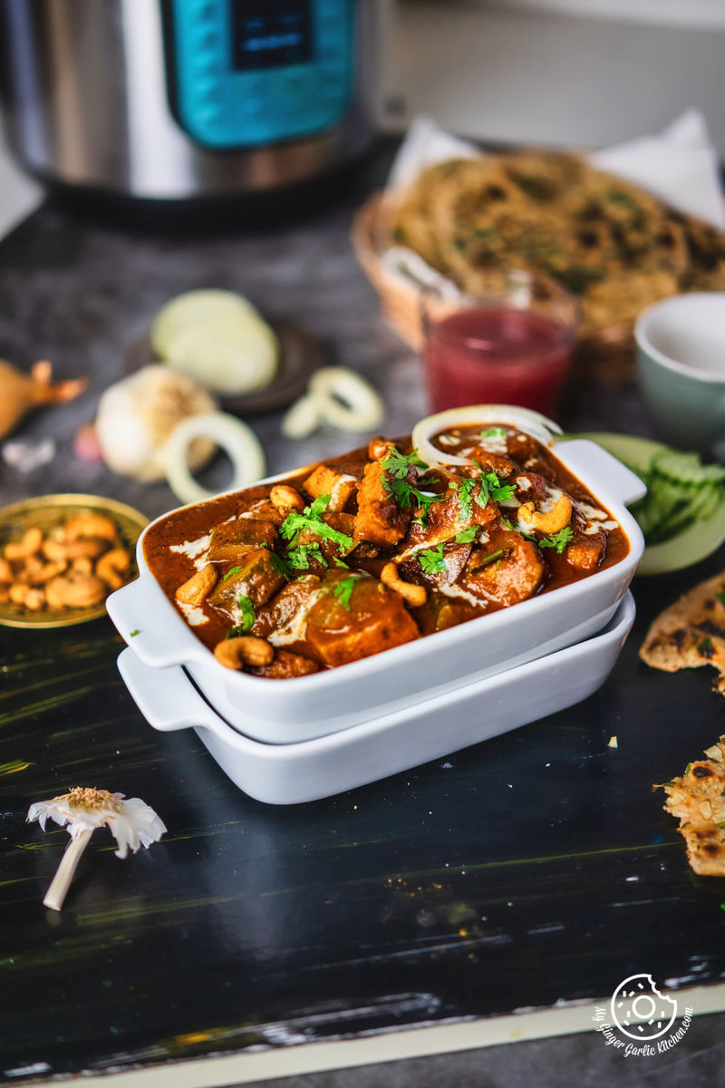 zucchini tofu curry topped with cilantro and cream served in a white rectangular casserole dish