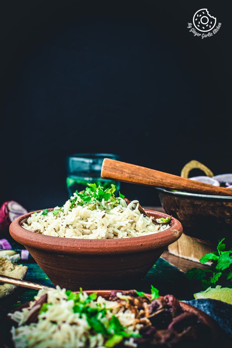 jeera rice bowl topped with fresh coriander leaves