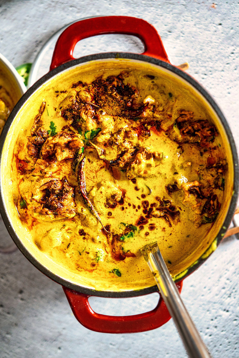 Delicious Kadhi Pakora in a cooking pot, showing the creamy curry with crispy pakoras immersed.