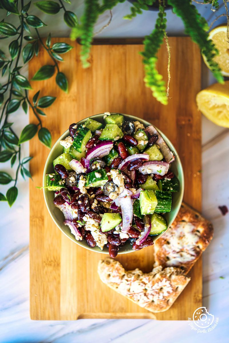 overhead photo of a bowl of kidney bean salad with bread and a lemon