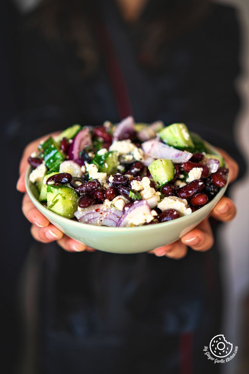 photo of a woman holding a bowl of kidney bean salad