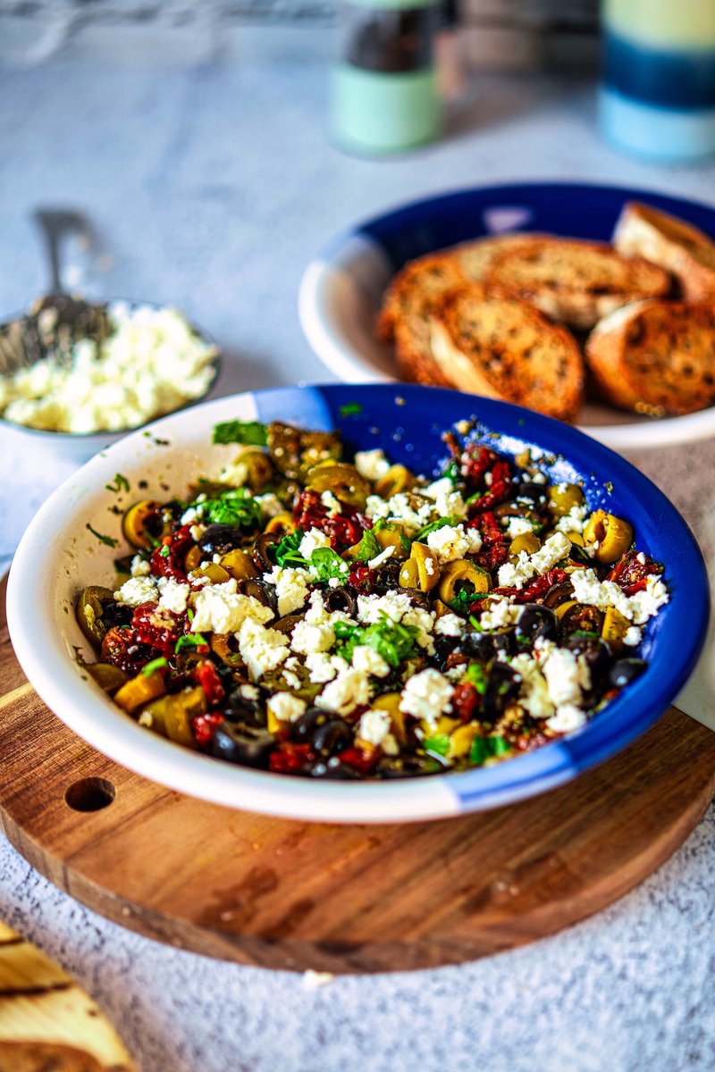 Mediterranean olive oil bread dip loaded with green and black olives, sun-dried tomatoes, feta, cilantro, and jalapeños