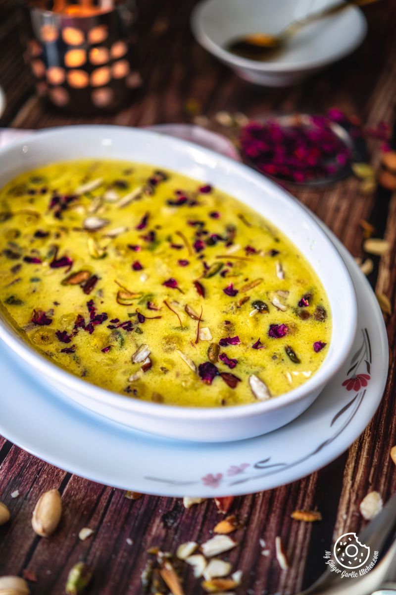 makhana kheer garnished with saffron and rose petals in a white oval shaped bowl