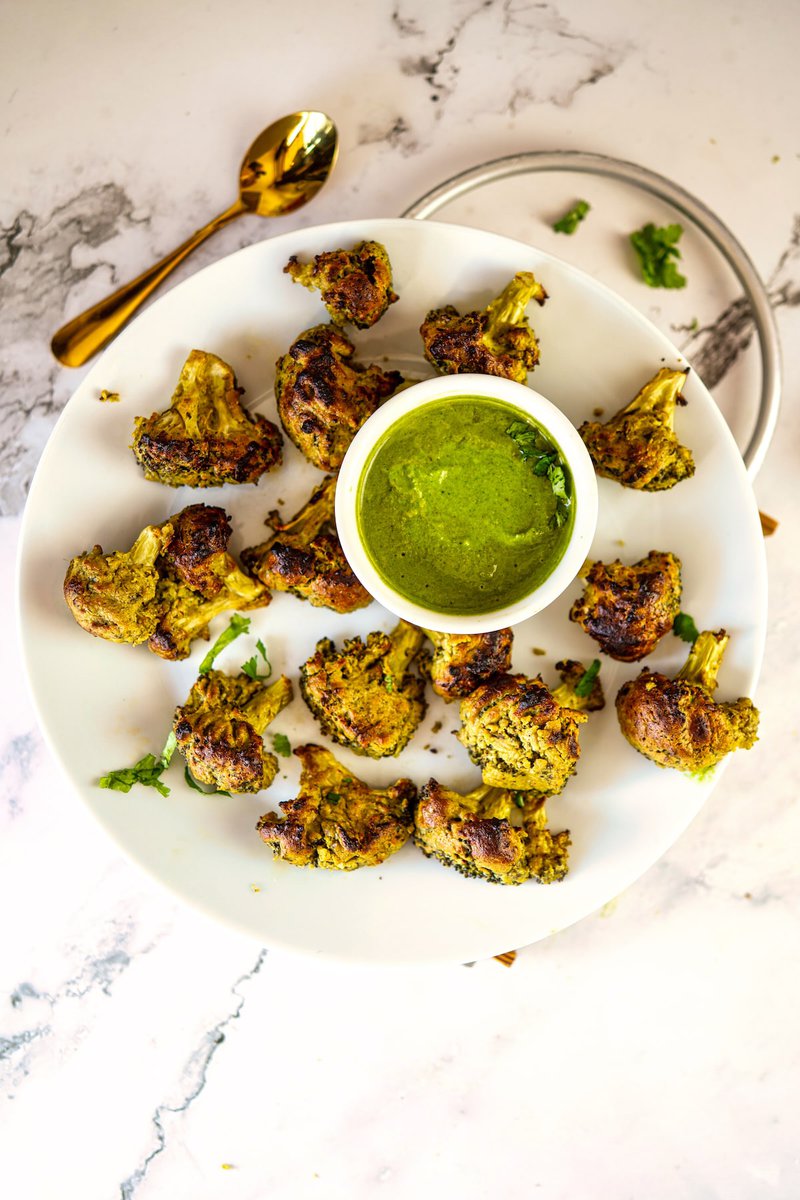 Plate of grilled Malai Broccoli florets served with green chutney.