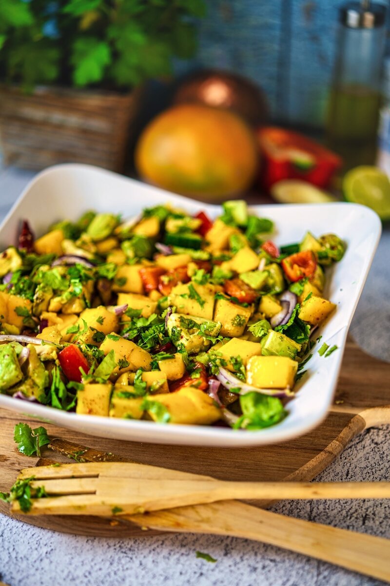 Vibrant tropical mango salad with avocado chunks Brussels sprouts herbs and colorful vegetables perfect healthy lunch option gluten free plant based recipe