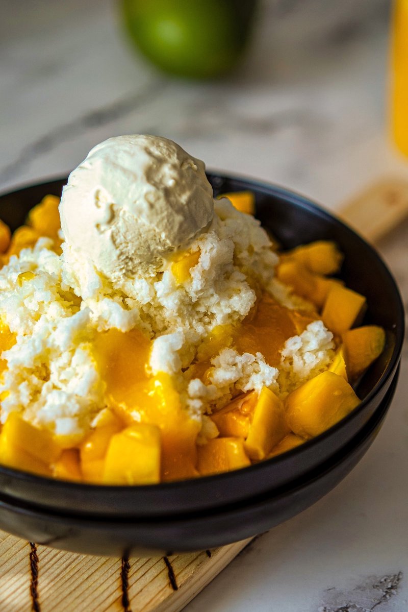 Close-up of homemade Mango Bingsu with fluffy milk ice, sweet mangoes, mango puree, and vanilla ice cream