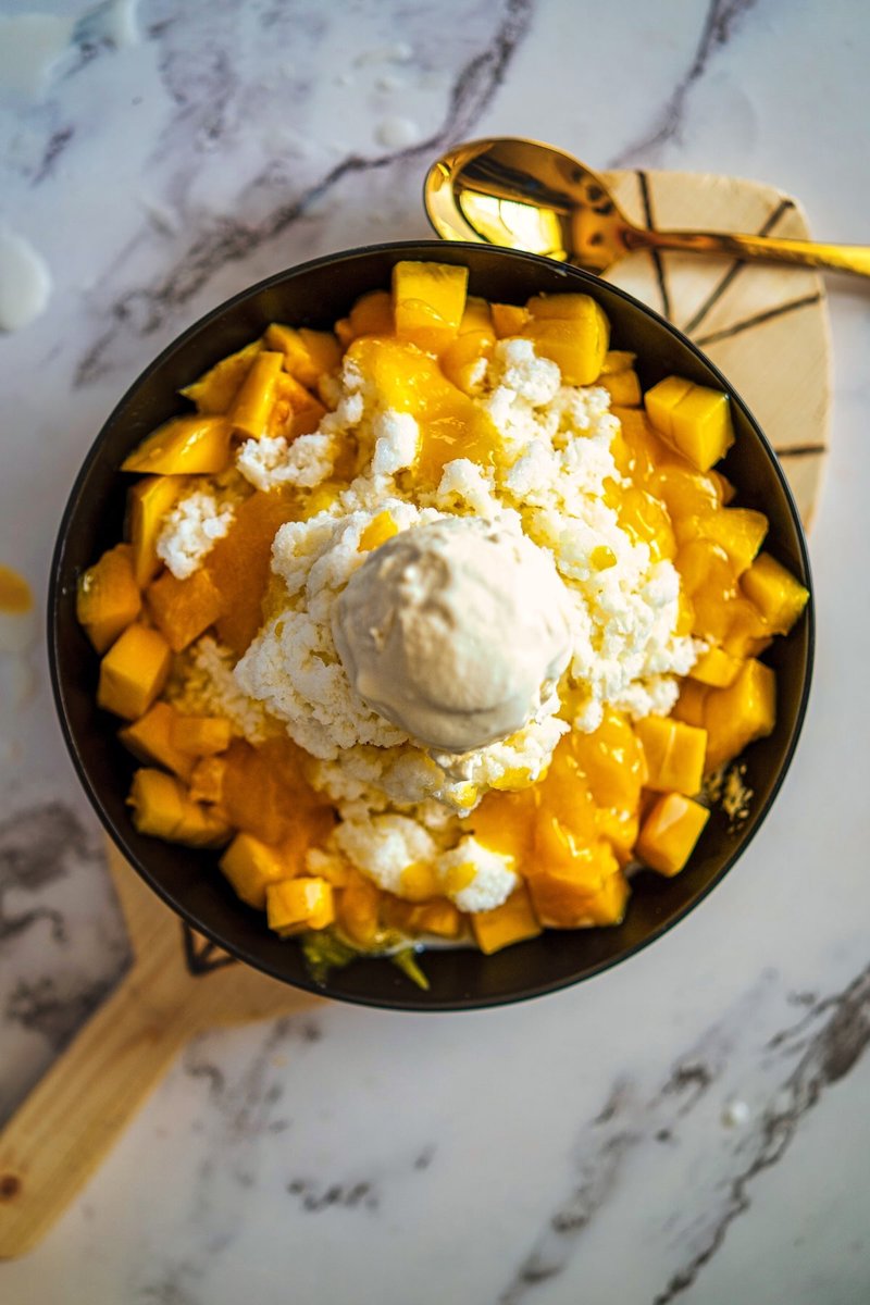 Top view of Korean Mango Bingsu made with shaved milk ice, fresh mango cubes, mango puree, and ice cream