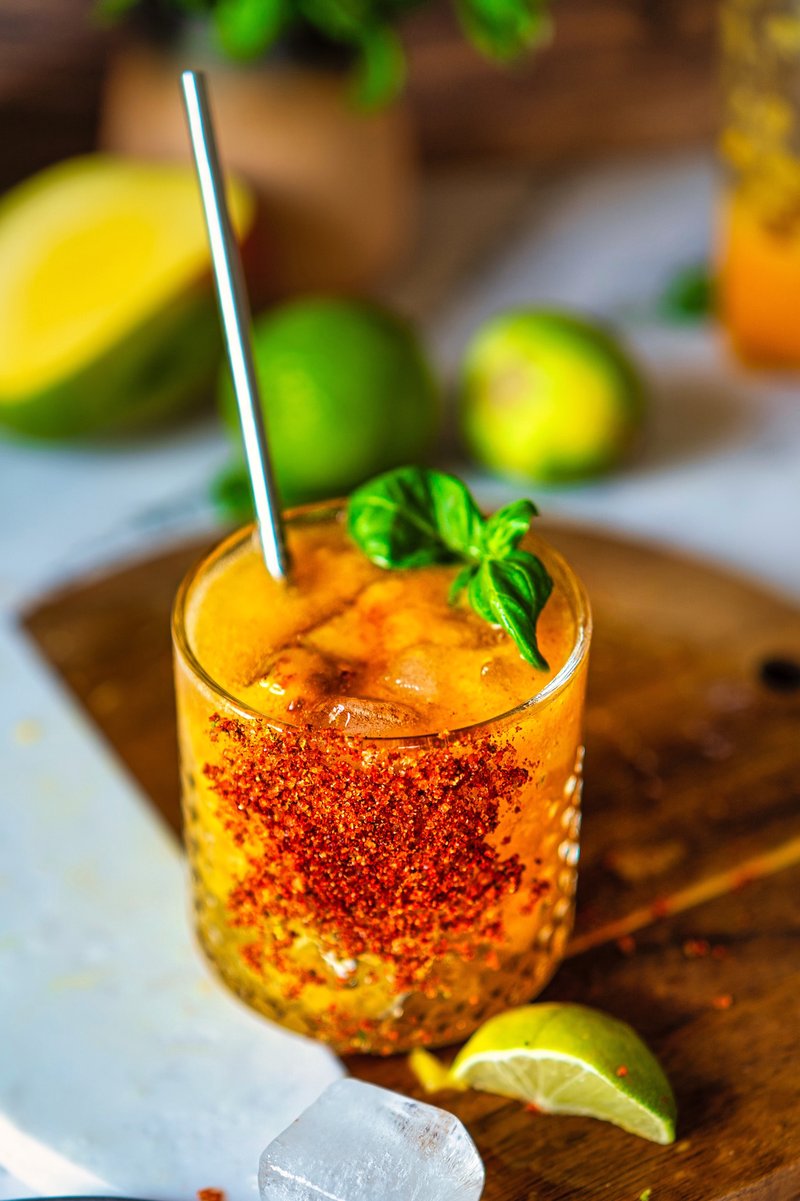 Mango Chili Lime Spritz with a chili-lime coated glass, fresh basil, ice cubes, and sparkling mango drink made with ripe mangoes and lime.