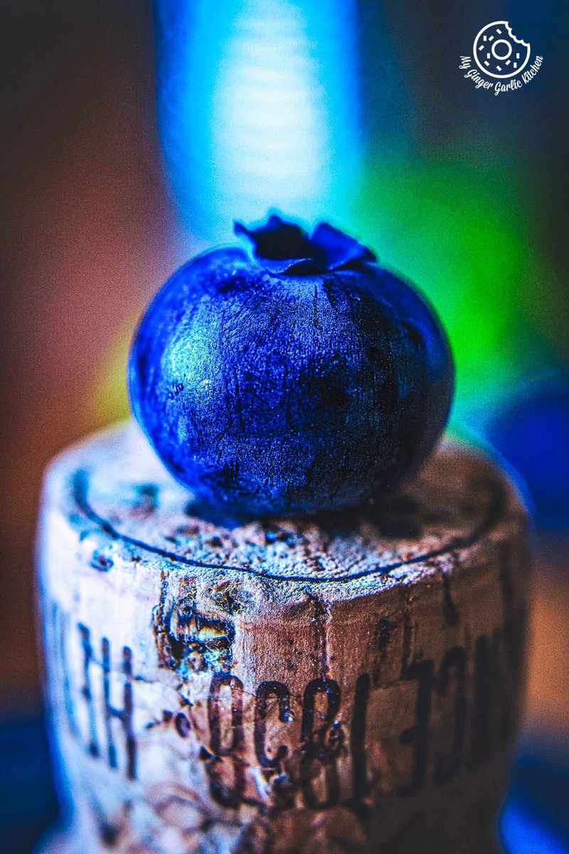 macro photo of  a blueberry on top of a cork stopper