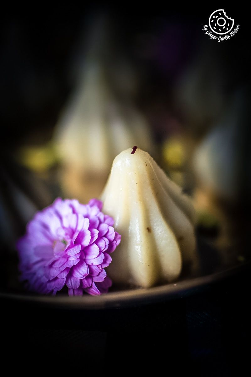 a small plate with some ukadiche modak on it and a flower