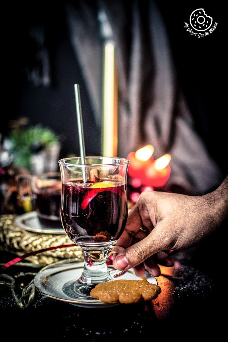 a male hand holding a glass of mulled wine