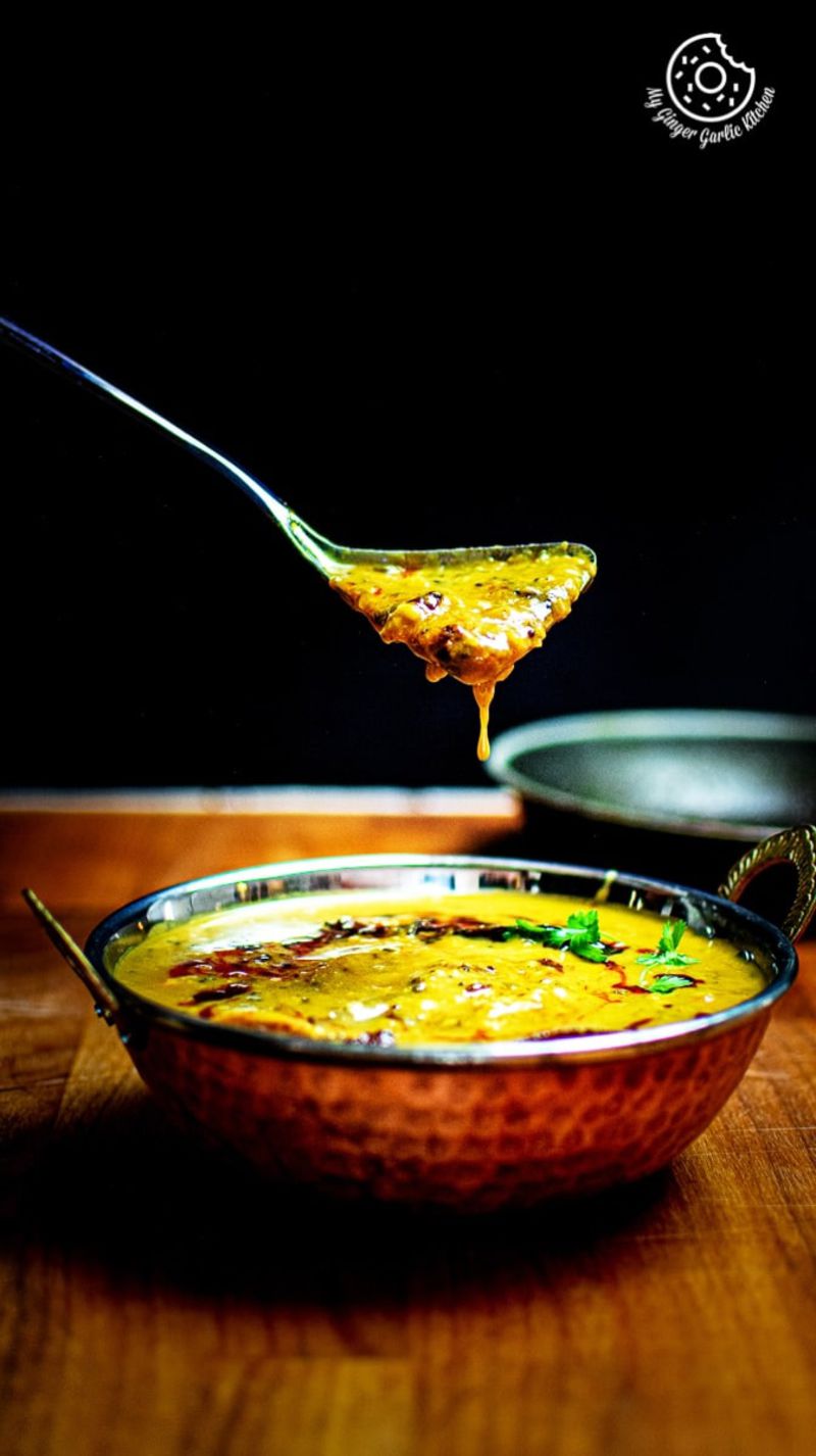 panchmel dal dripping from a metal spoon