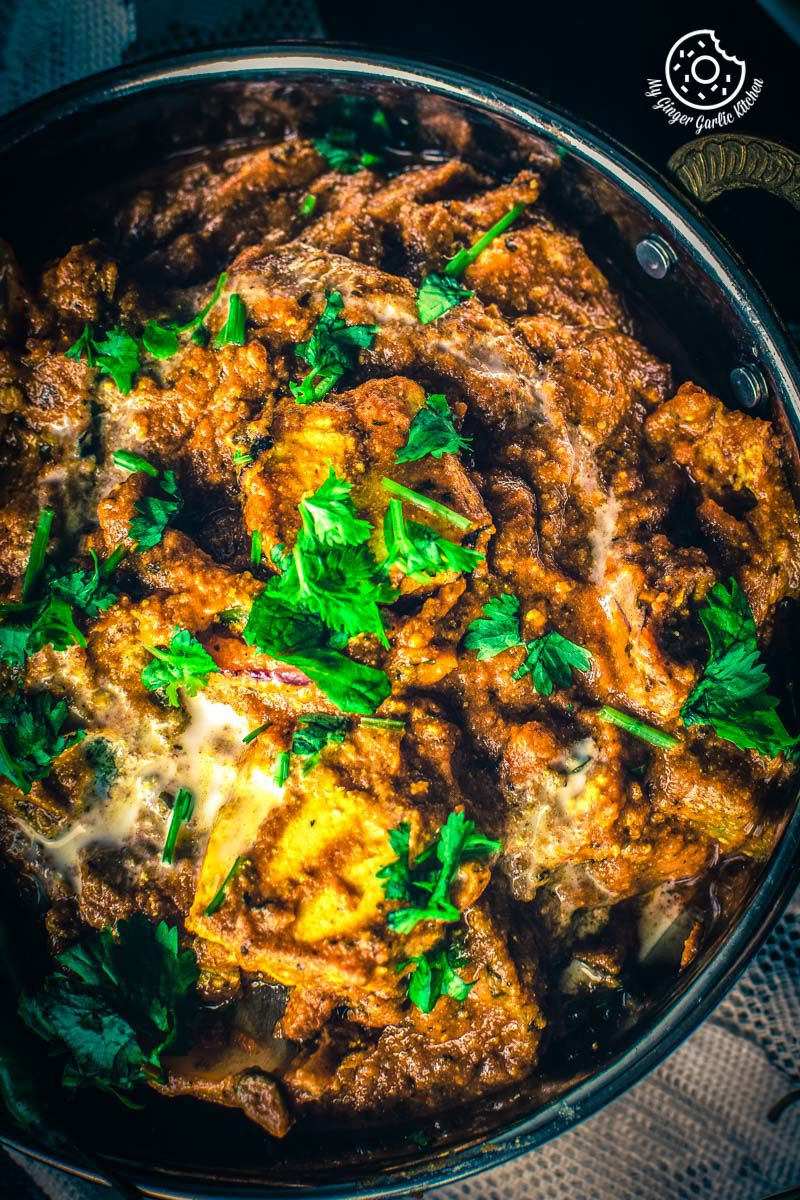 a close up of a pan of paneer tikka masala with chopped cilantro on it