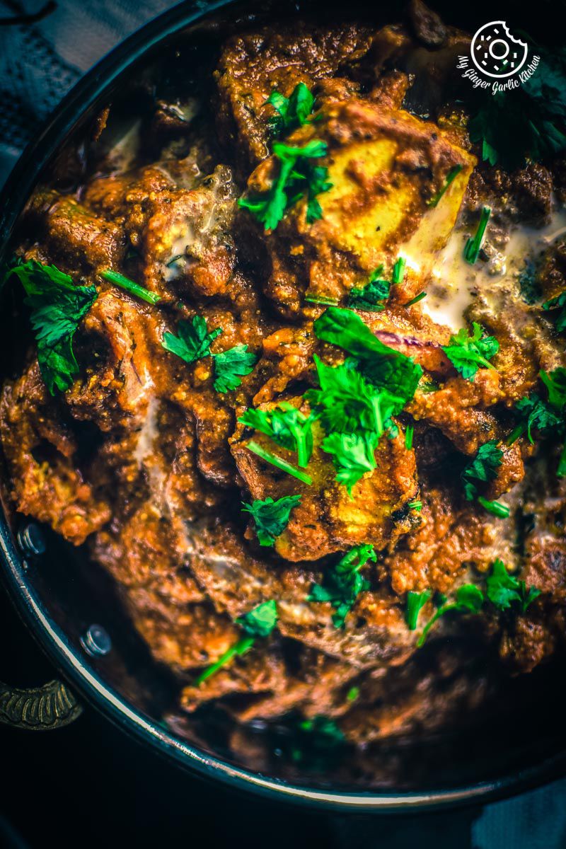 a close up of a pan filled with paneer tikka masala topped with butter