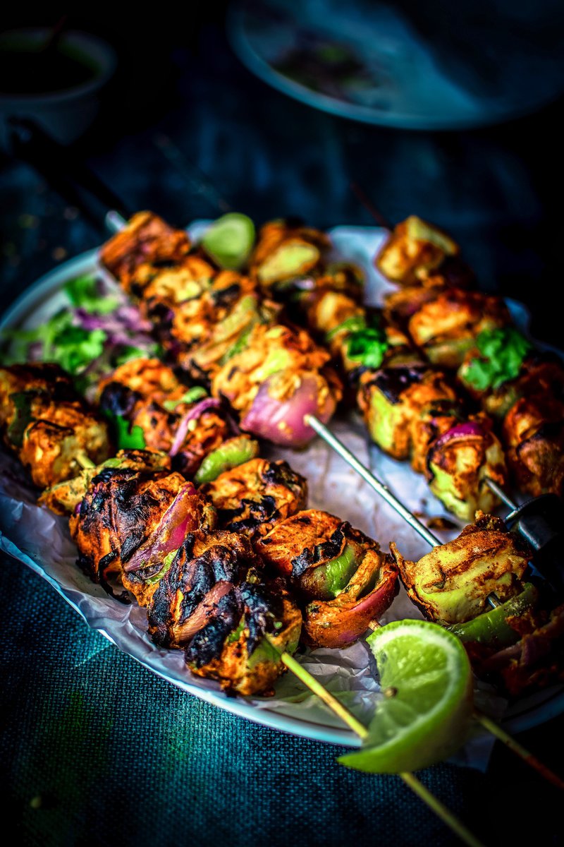 A tantalizing close-up of paneer tikka skewers with a wedge of lime, ready to be served.