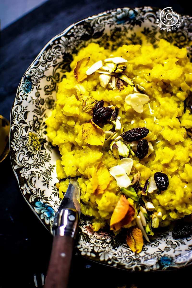 a closeup of a bowl of jaipuri paush khichda aka sweet dal khichdi with a spoon on the table