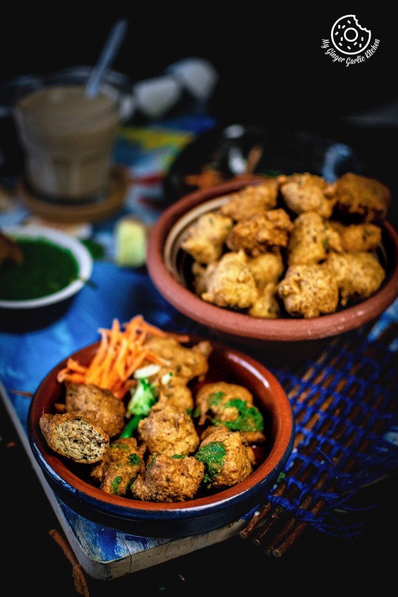 bowls of paush vada with carrots on a table with a blue boars