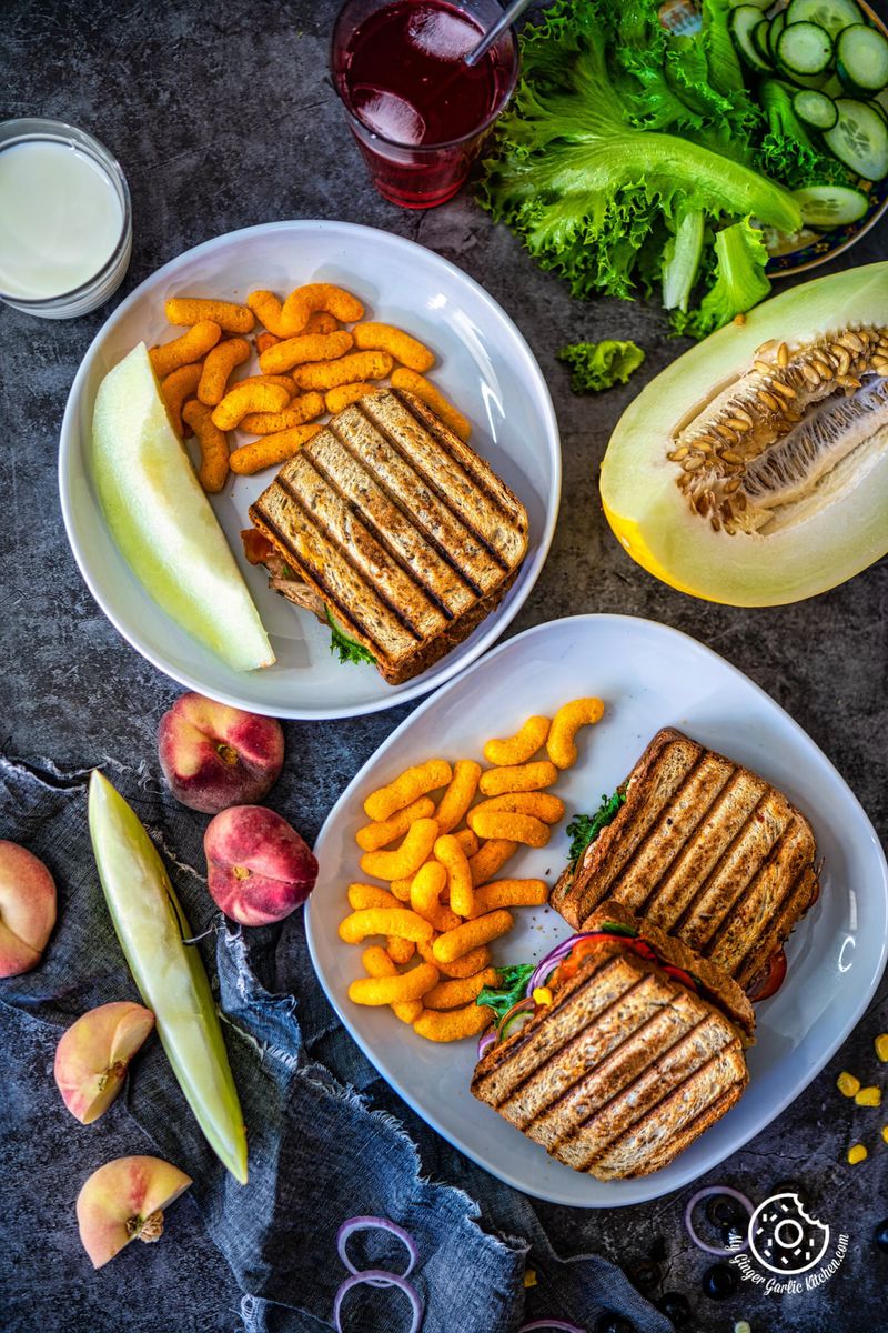 overhead shot ocf peanut butter and veggie grilled cheese sandwiches along with melon and cheese puffs