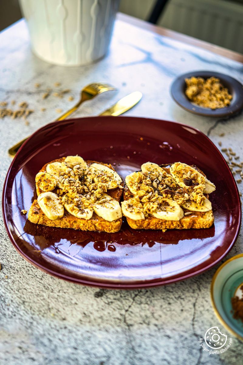 photo of a plate of peanut butter banana toast and granola on a table