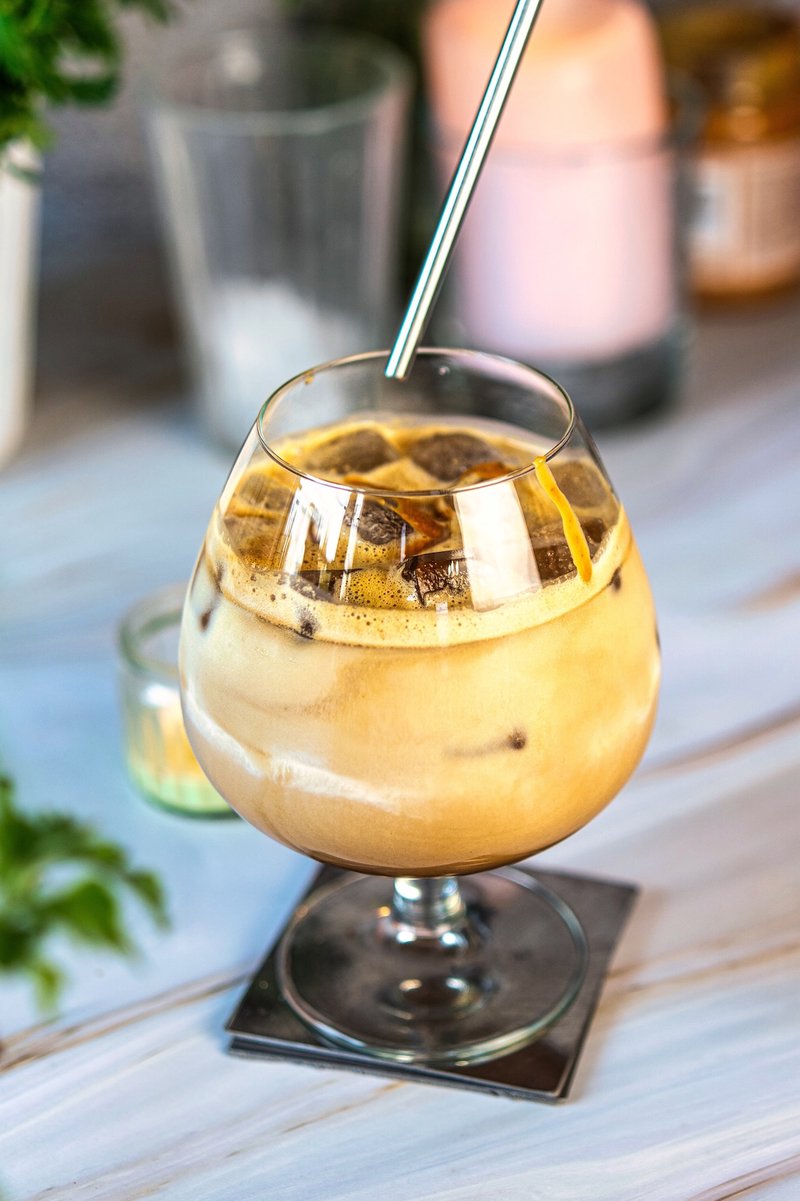 Creamy homemade peanut butter iced latte with ice and a straw
