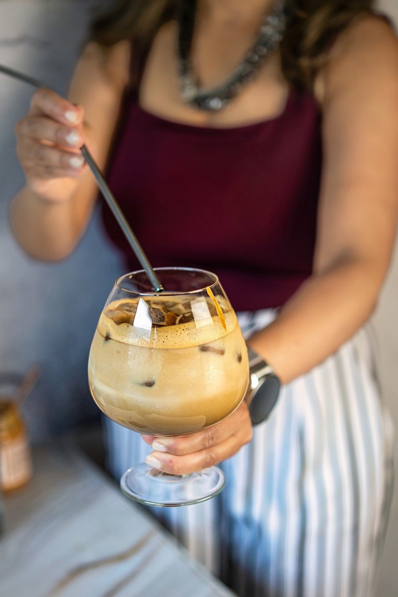 Homemade peanut butter iced latte served in a glass and enjoyed with a straw
