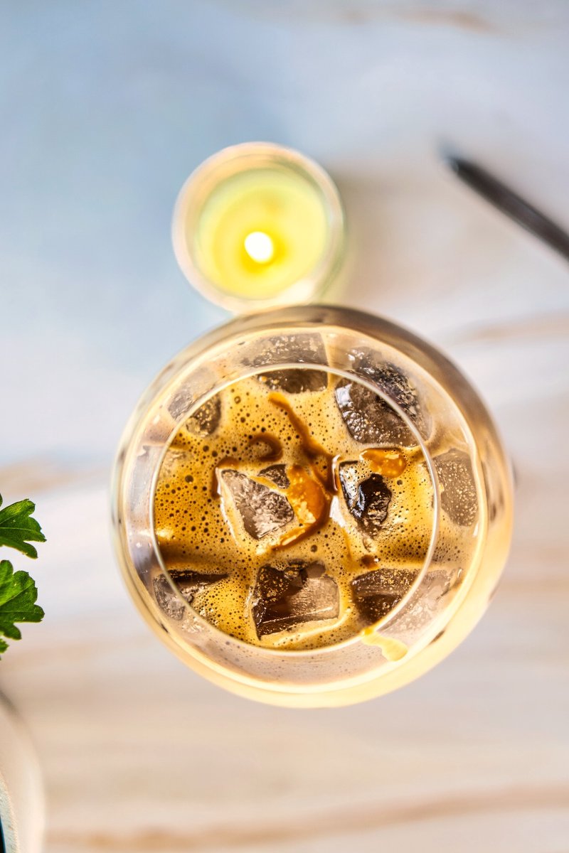 Overhead view of a peanut butter iced latte with coffee, ice and peanut butter drizzle