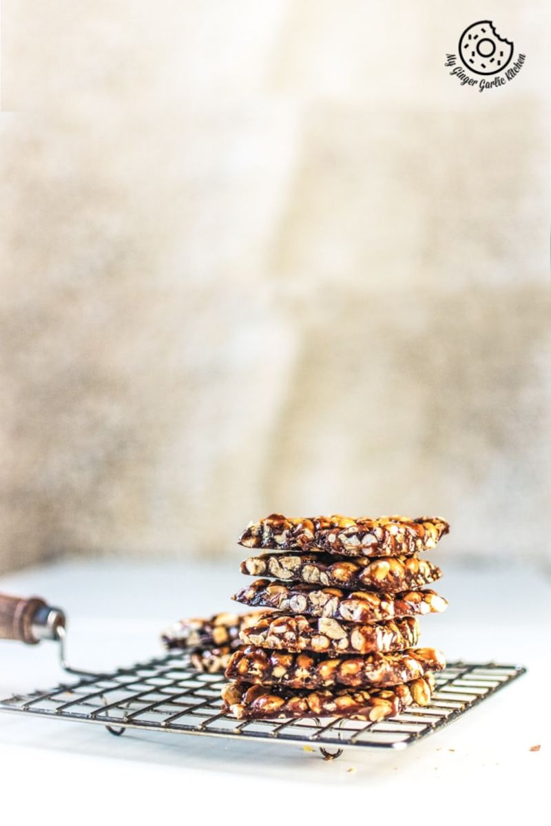 a stack of peanut chikkis on a cooling rack on a table