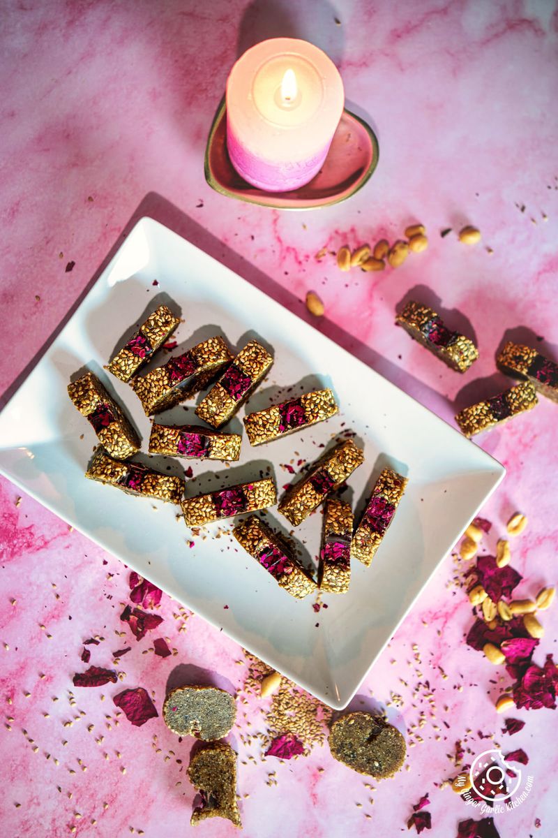 overhead shot of peanut date roll in a white rectangle plate with a pink candle on the side