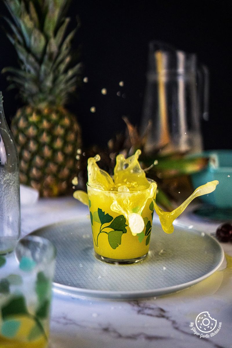 Pineapple juice splashing from a glass
