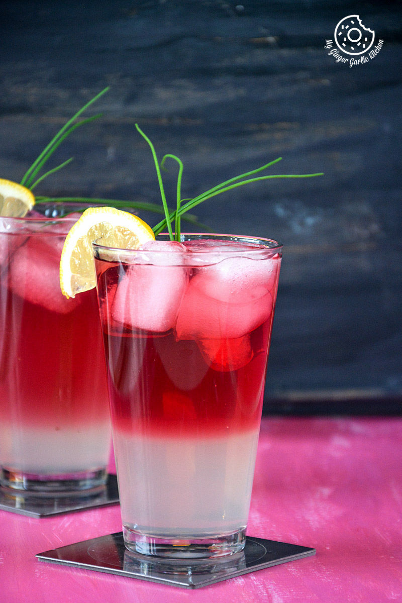 two glasses of watermelon lemonade with lemon slices on top