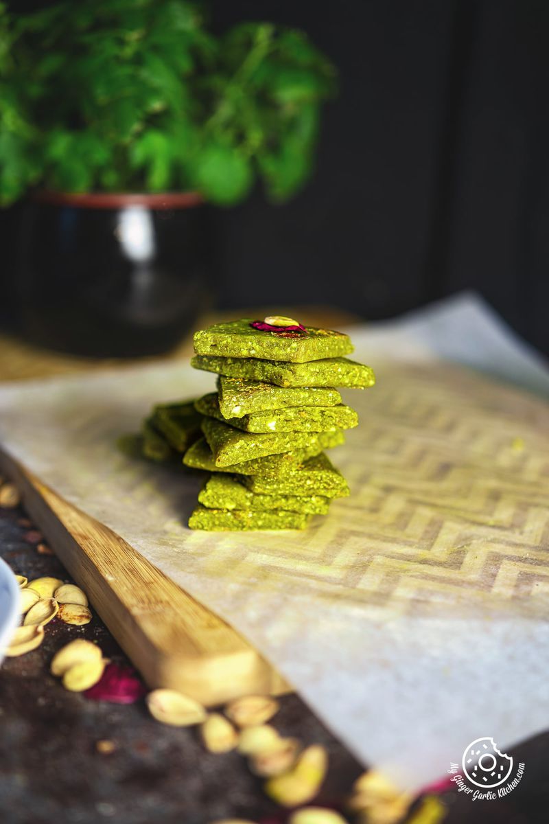 a stack of pista katli kept on a parchment paper lined wooden board