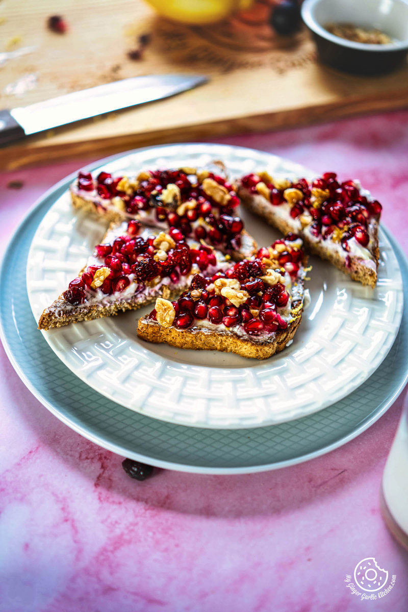 a plate with pomegranate toasted bread and fruit on it