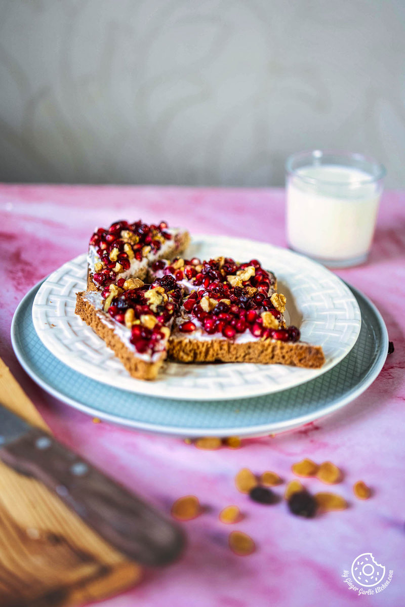 a plate with four pieces of pomegranate toast on it