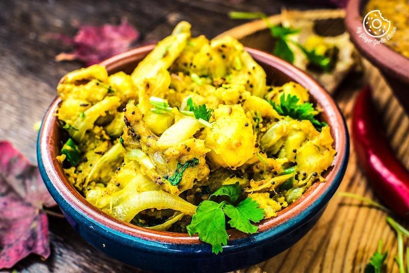 a bowl of aloo bhaji with some leaves