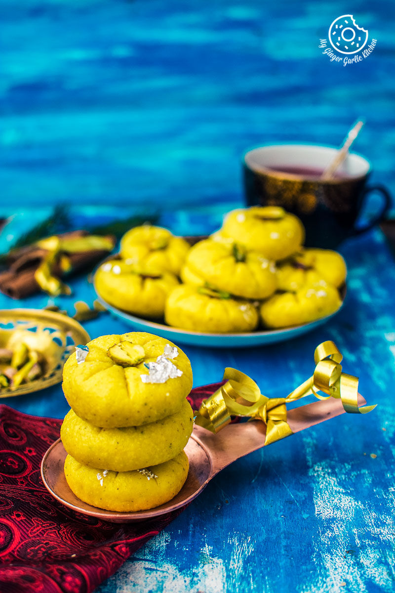 two plates of kesar peda on a blue table