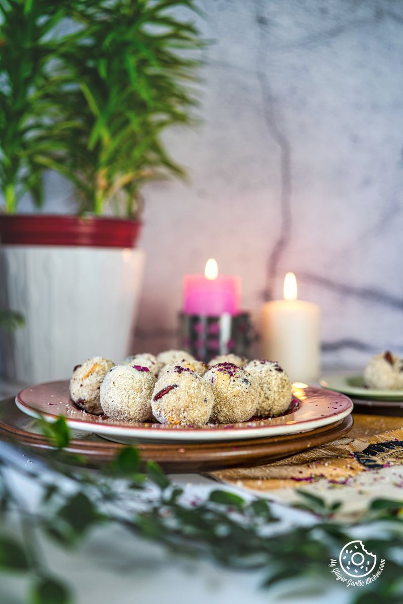 photo of a plate of Rava Ladoo on a table with candles