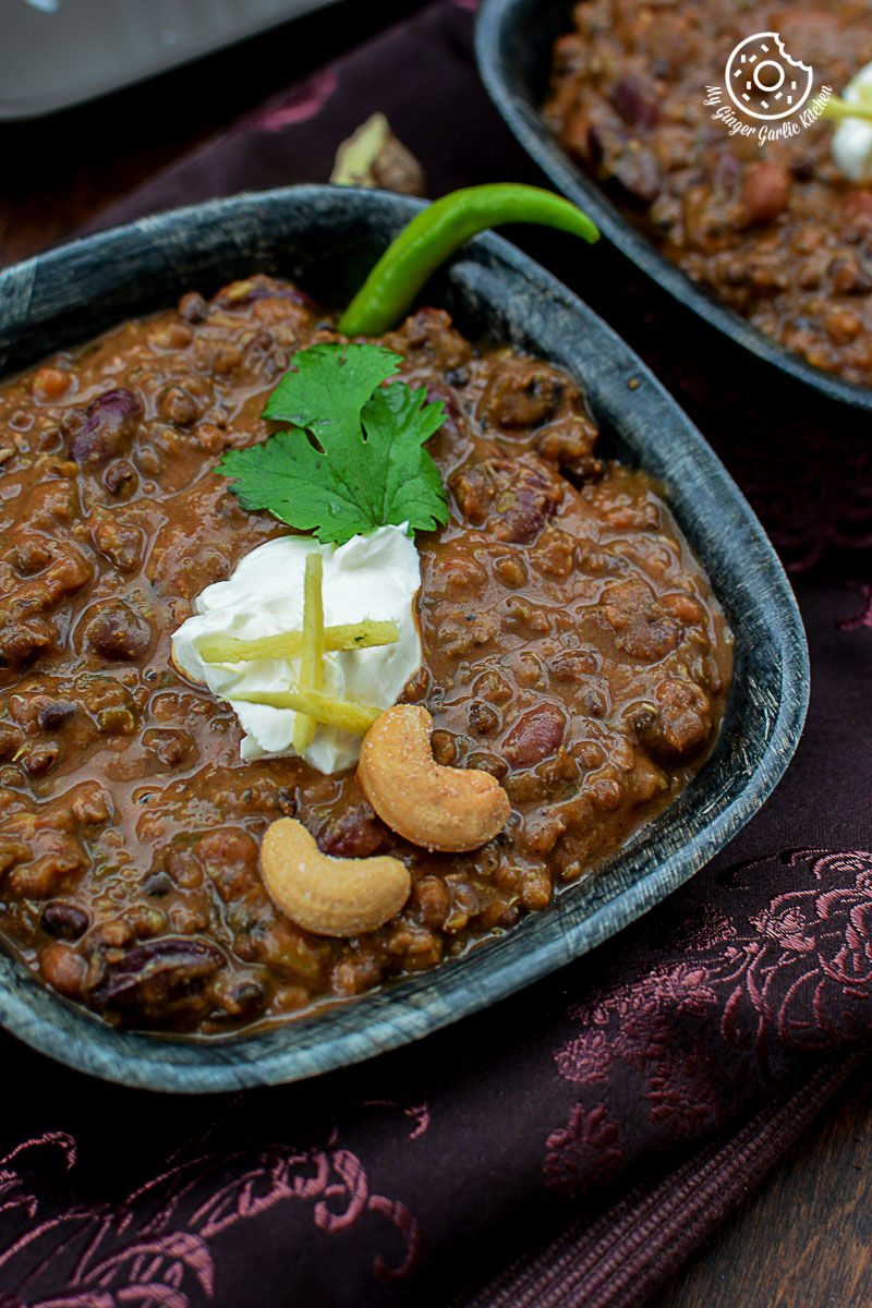 two bowls of three bean thick dal makhani with cream and cashews on a table