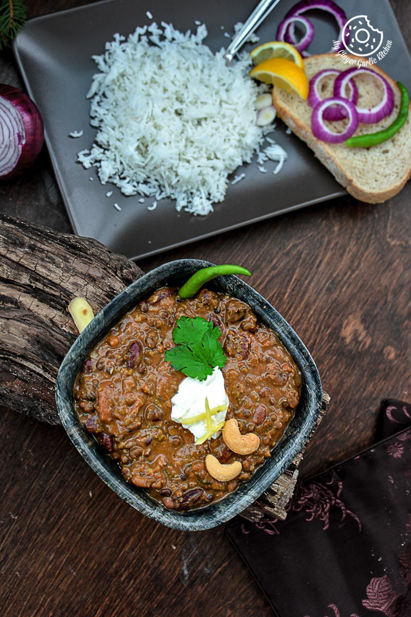 a bowl of three bean thick dal makhani and rice on a table
