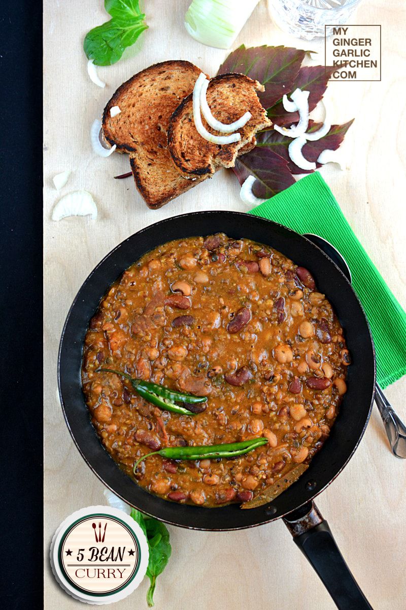 a pan of 5 bean curry in a bowl and some toasted bread on a table