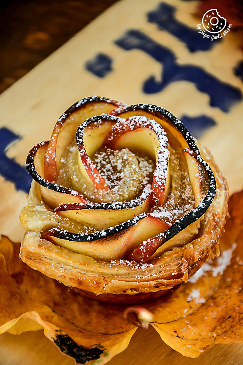 a apple rose mini tartlet with apples and powdered sugar on top