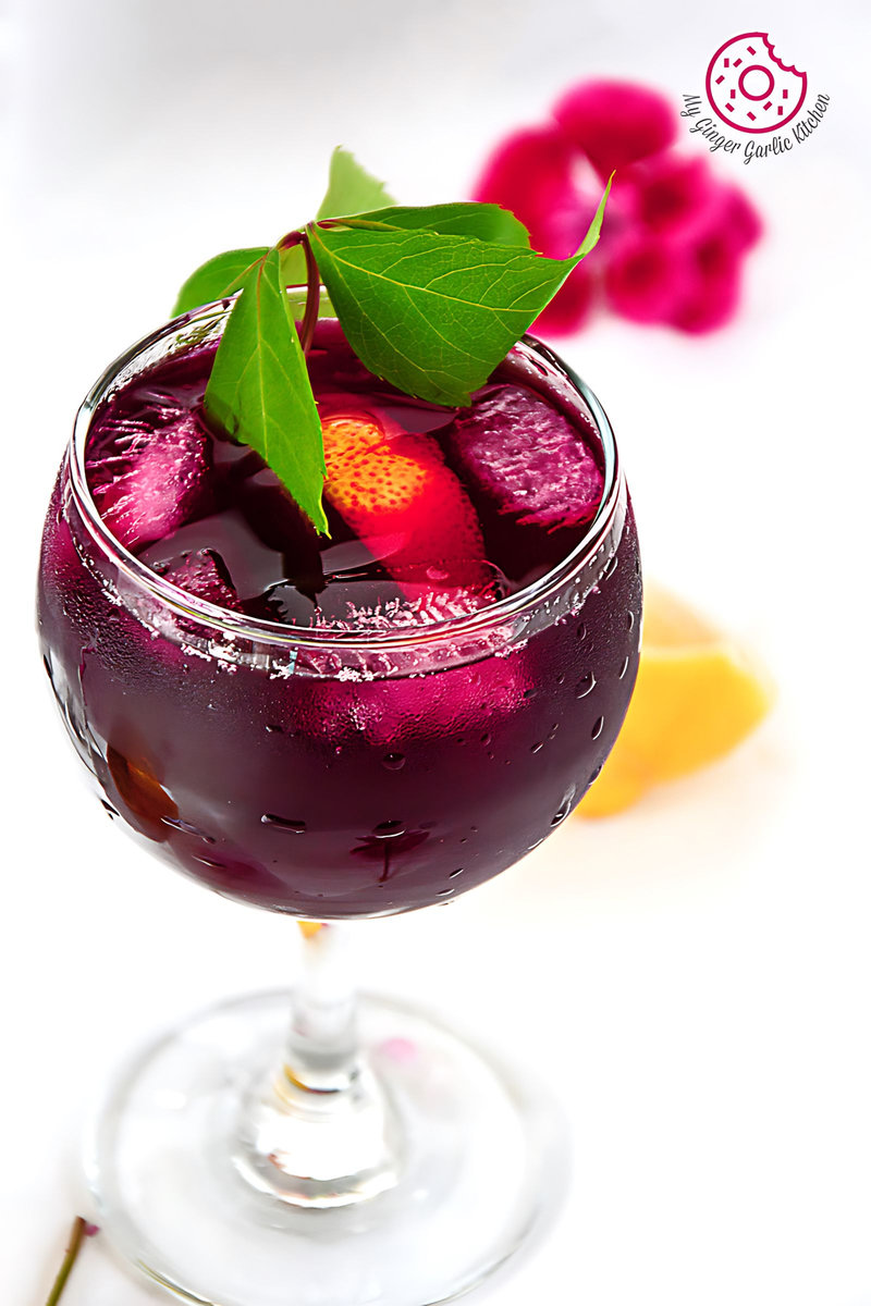 a glass of beet lemonade with a ice cubes inside of it