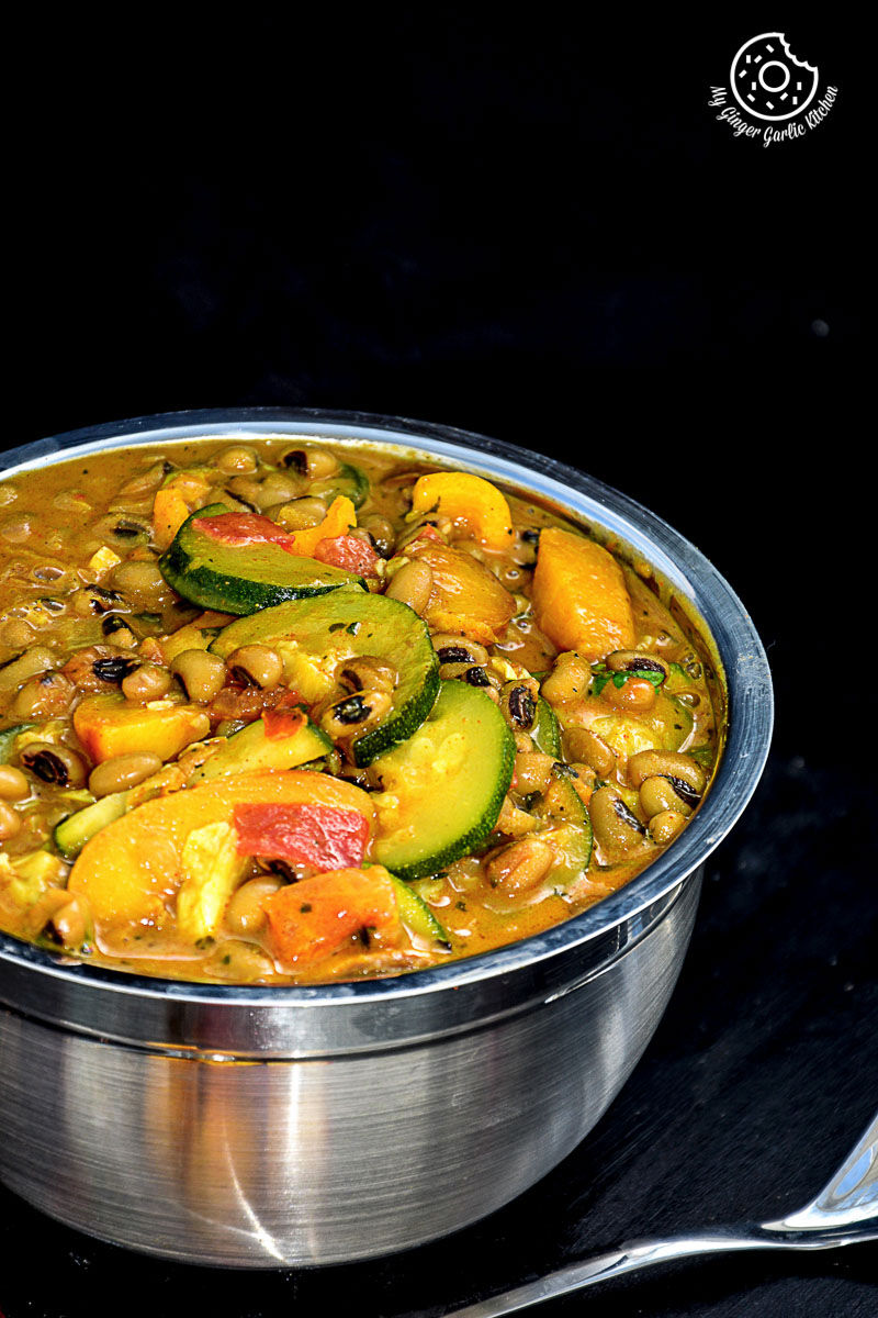 a bowl of black eyed bean zucchini peach curry with a fork
