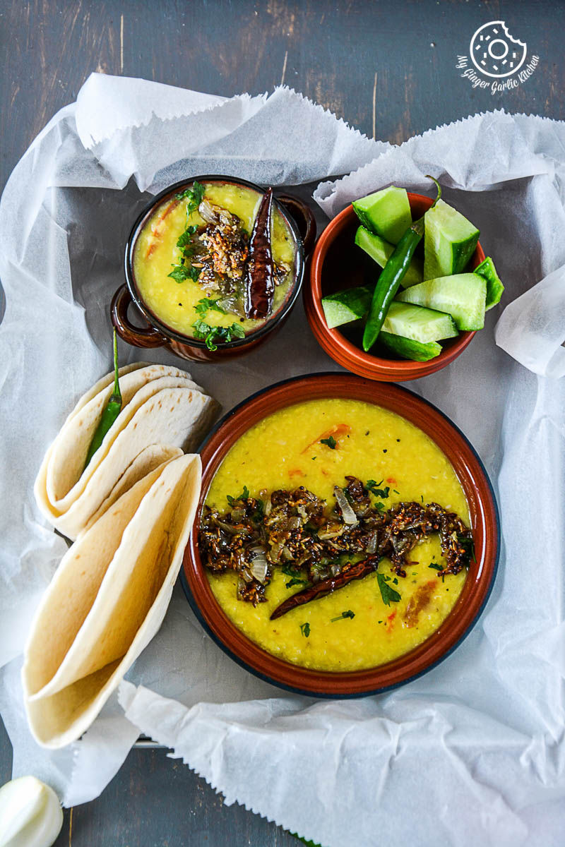two bowls of cardamom scented moong dal tadka and a tortilla on a table