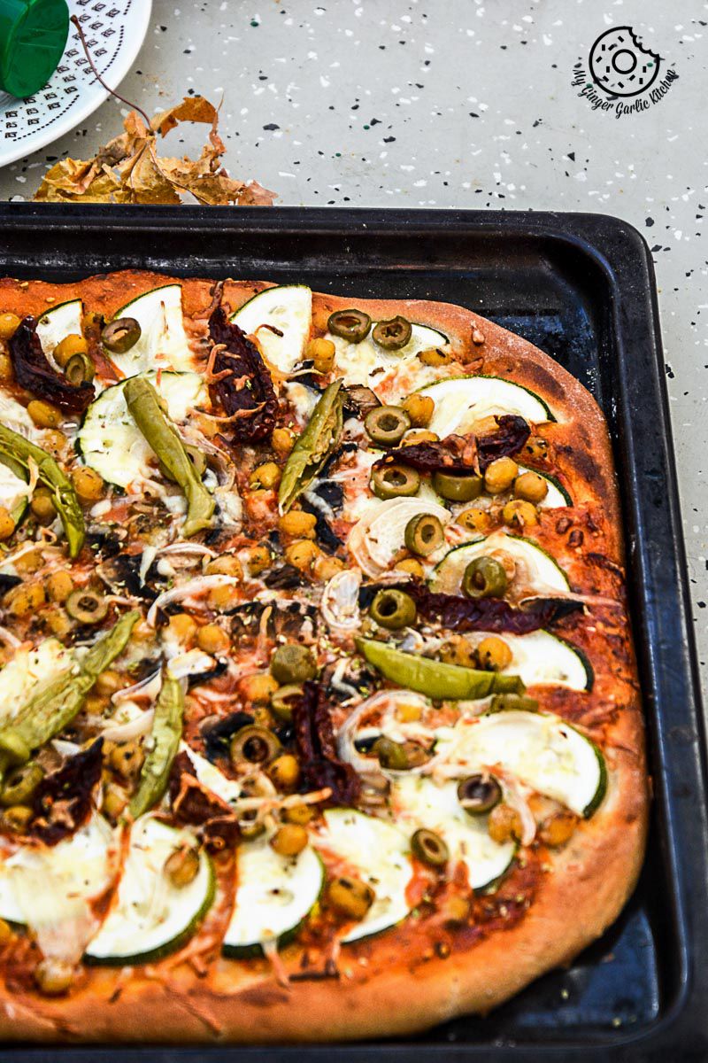 a chickpea zucchini mushroom pizza with and olives and other toppings on it