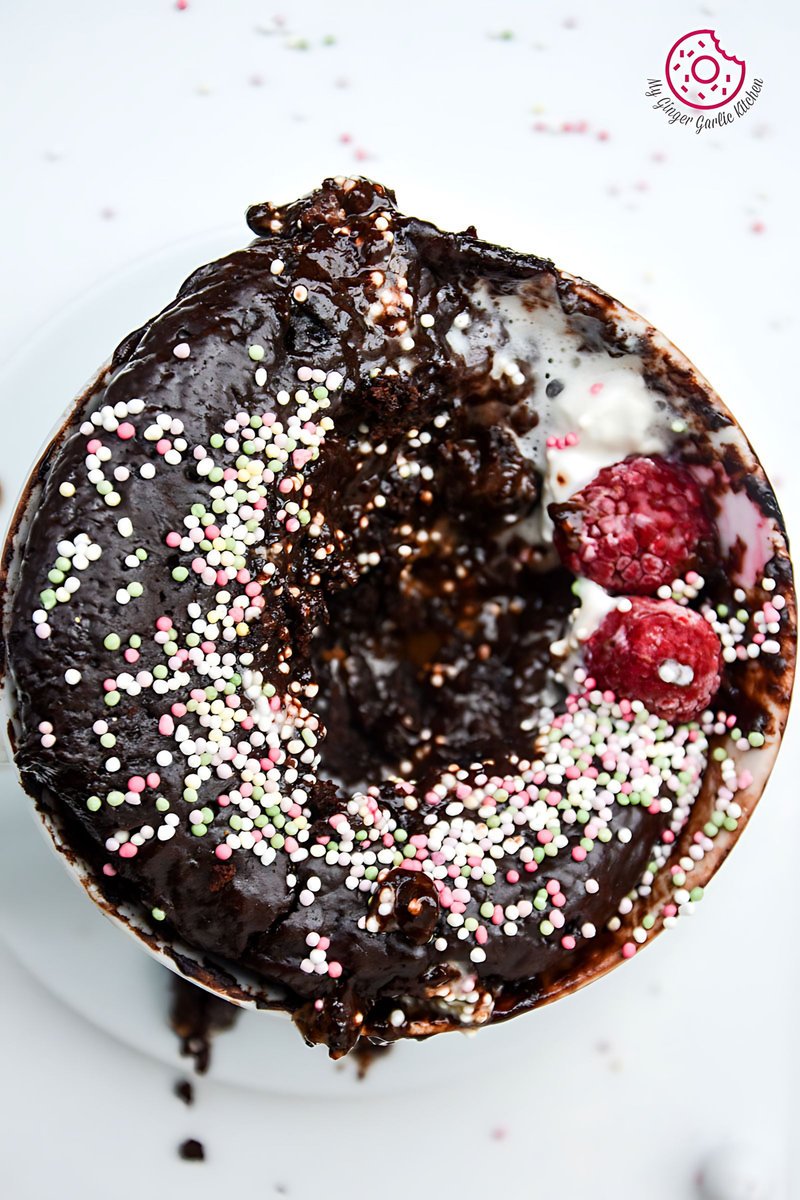 chocolate molten lava mug cake with sprinkles and a raspberry on top