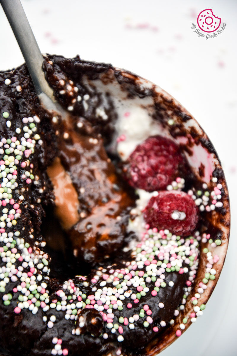 chocolate molten lava mug cake with sprinkles and a spoon in it
