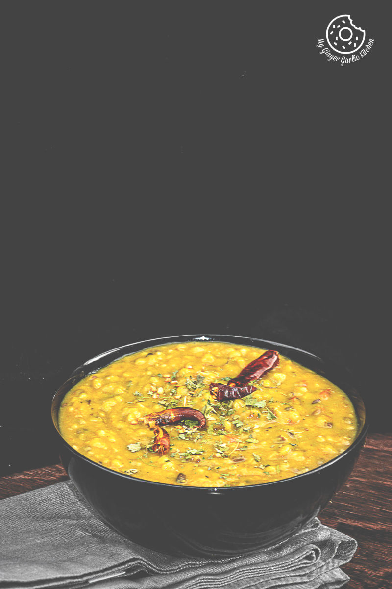 a bowl of dal topped with kasuri methi and dried red chilies