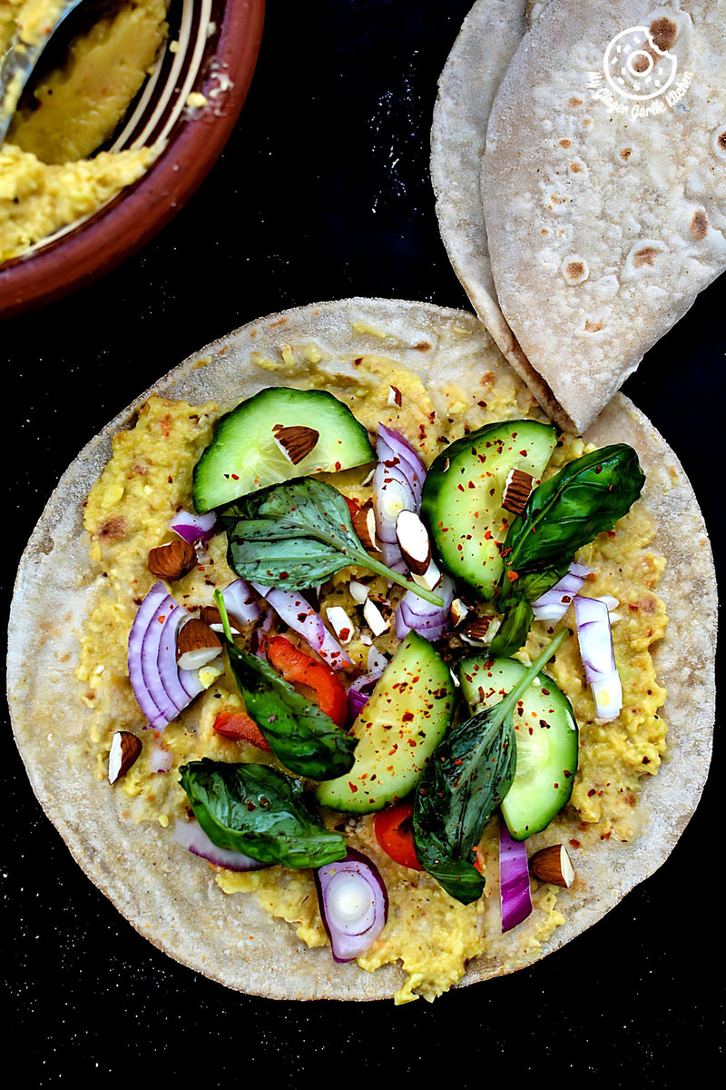 indian chapati with peppery garlicky avacado spread and other ingredients on a table